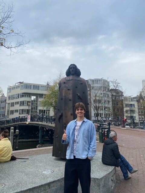 Image of Brown Payne standing in front of a bronze statue