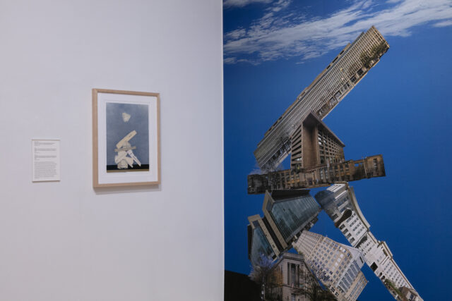 Framed collage of geometric shapes in muted tones mounted next to a full-wall collage of cut and reassembled architectural photographs against a bright blue sky.