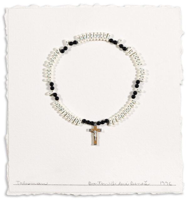 A handmade rosary with white and black beads and a crucifix is arranged in a circle on textured white paper. The words Talisman, Barton Lidice Beneš, and 1996 are handwritten along the bottom edge.