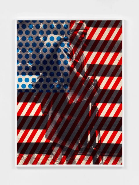 Vertical American flag with blue dots and red diagonal stripes overlaying a black and white image of an African American soldier