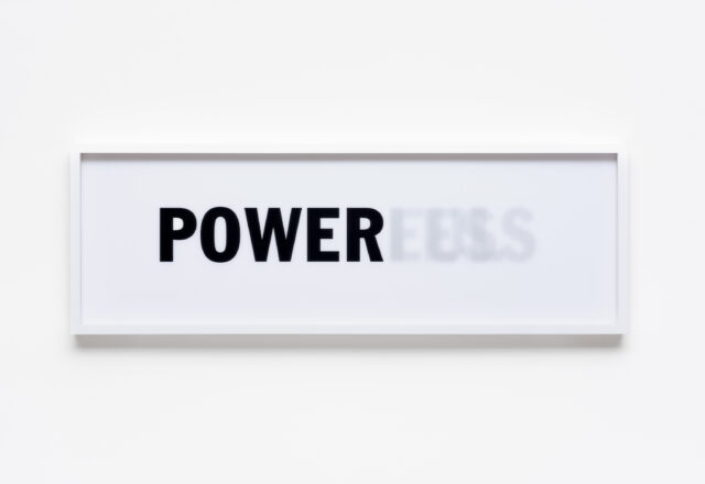 Framed sign reading 'POWER' in bold black letters, with a faded 'LESS' after it
