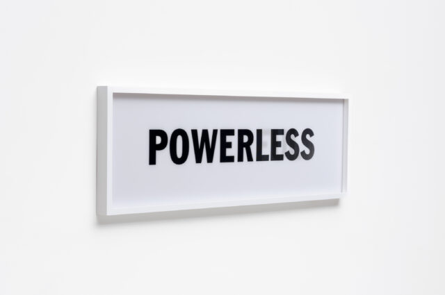 White sign with 'POWERLESS' in bold black letters